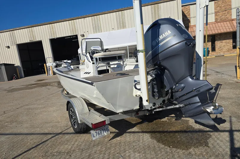 Slide: The Image of 2015 G3 Bay 18 DLX boat with Yamaha motor on trailer, parked outside a warehouse. - 2