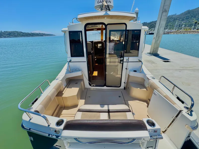 Slide: The Image of 2015 Cutwater C26 boat docked, featuring spacious seating and Garmin navigation system. - 13