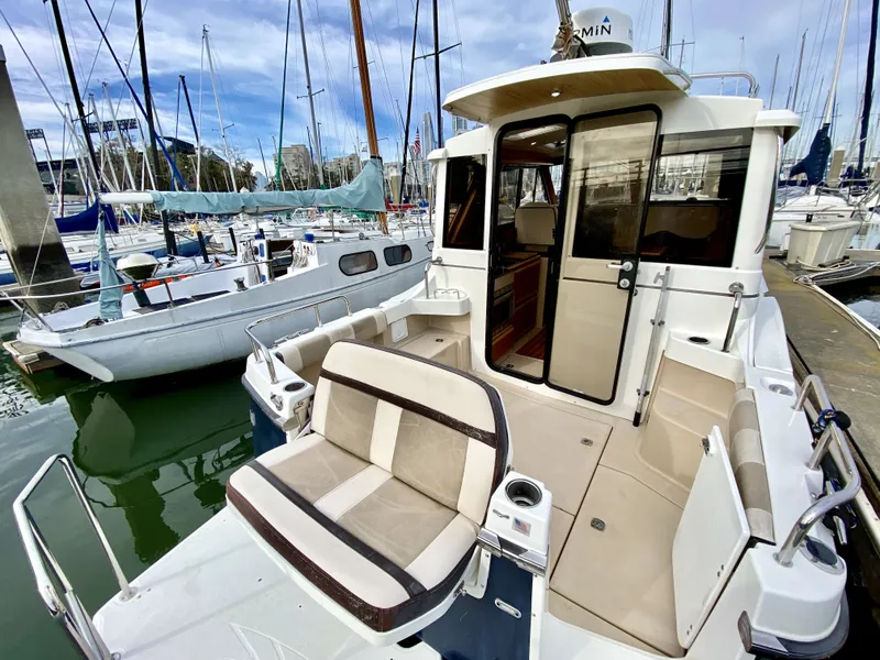 Slide: The Image of 2015 Cutwater C26 boat docked at marina, featuring open cockpit and seating area. - 14