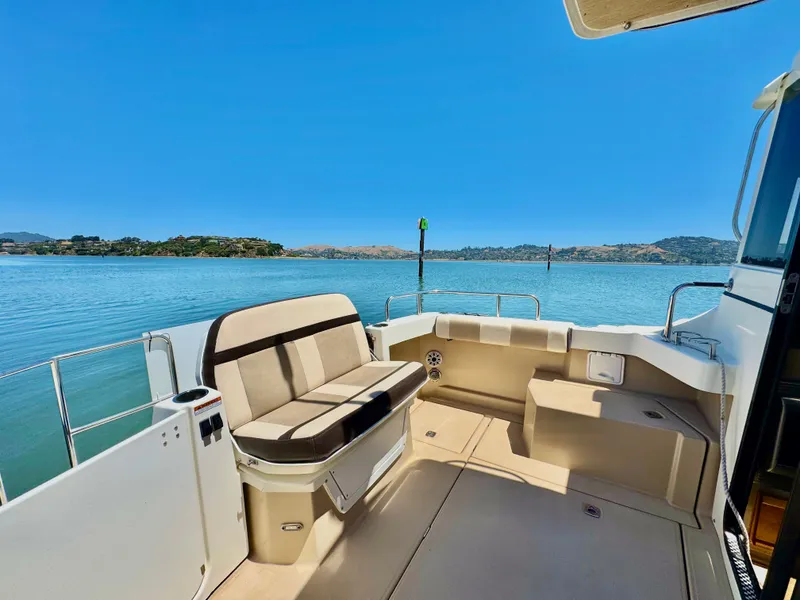 Slide: The Image of 2015 Cutwater C26 boat deck with seating, overlooking serene blue waters and distant hills. - 15