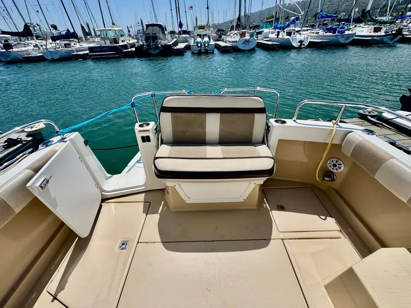 Slide: The Image of 2015 Cutwater C26 boat interior with seating, docked in a marina. - 16