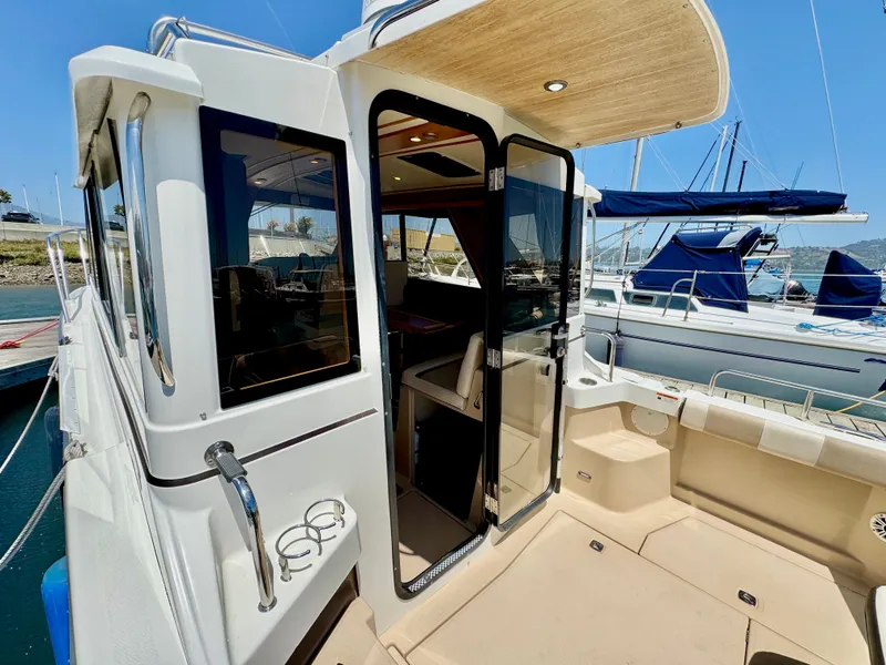 Slide: The Image of 2015 Cutwater C26 boat with open cabin door, docked at marina. - 18