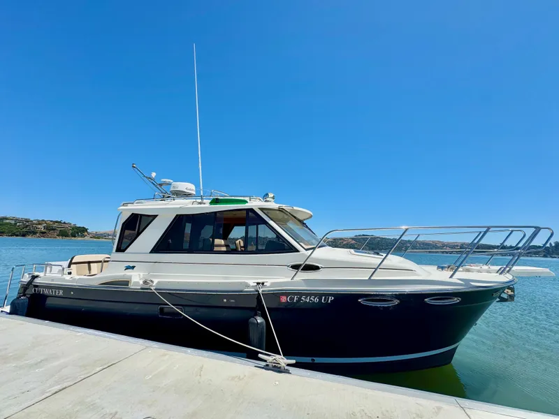 Slide: The Image of 2015 Cutwater C26 boat docked on a sunny day, showcasing sleek design and modern features. - 2