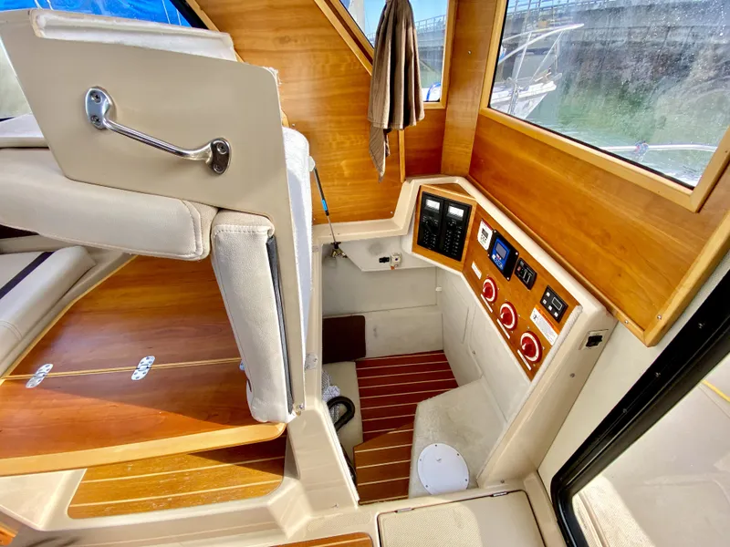 Slide: The Image of Interior of a 2015 Cutwater C26 boat, featuring control panels and wooden accents. - 21