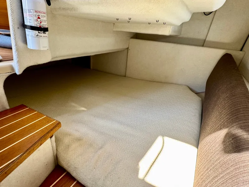 Slide: The Image of 2015 Cutwater C26 cabin interior with beige upholstery and wooden steps. - 25