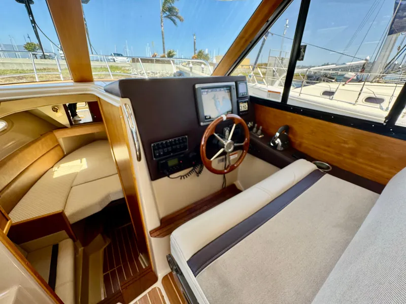 Slide: The Image of 2015 Cutwater C26 boat interior with helm, navigation system, and seating area. - 28