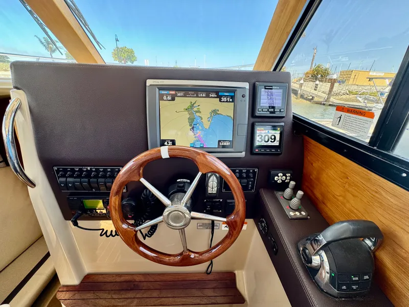 Slide: The Image of Helm of 2015 Cutwater C26 boat with navigation screens and wooden steering wheel. - 29