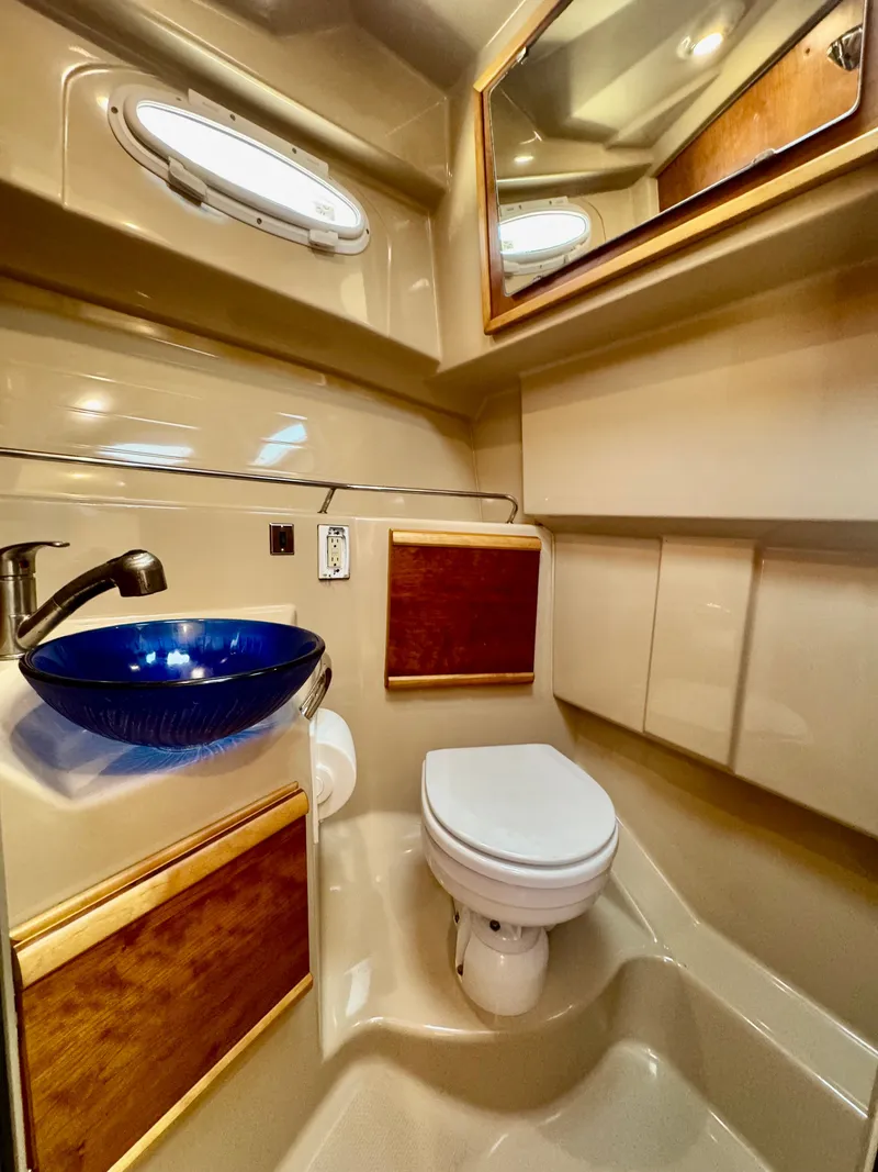 Slide: The Image of 2015 Cutwater C26 boat bathroom with blue sink, toilet, and wood accents. - 38