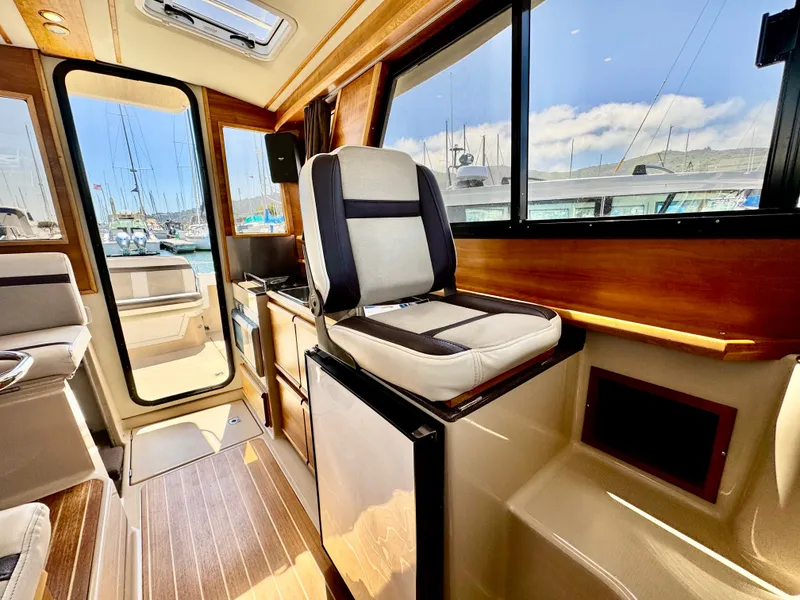 Slide: The Image of Interior of a 2015 Cutwater C26 boat, featuring seating and wood accents. - 42