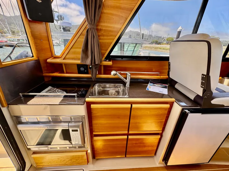 Slide: The Image of 2015 Cutwater C26 boat interior with kitchenette, featuring sink, stove, and microwave. - 43