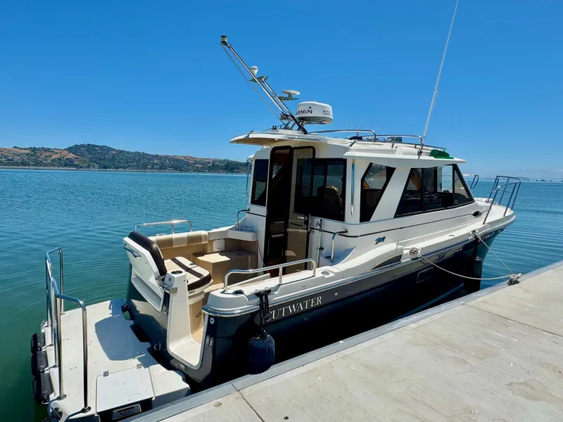 Slide: The Image of 2015 Cutwater C26 boat docked on a sunny day, with clear blue water and sky. - 9