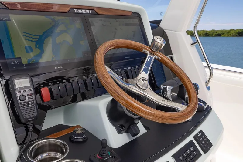 Slide: The Image of Manufacturer Provided Image: 2025 Pursuit S 328 Sport boat dashboard with Garmin navigation and wooden steering wheel. - 11