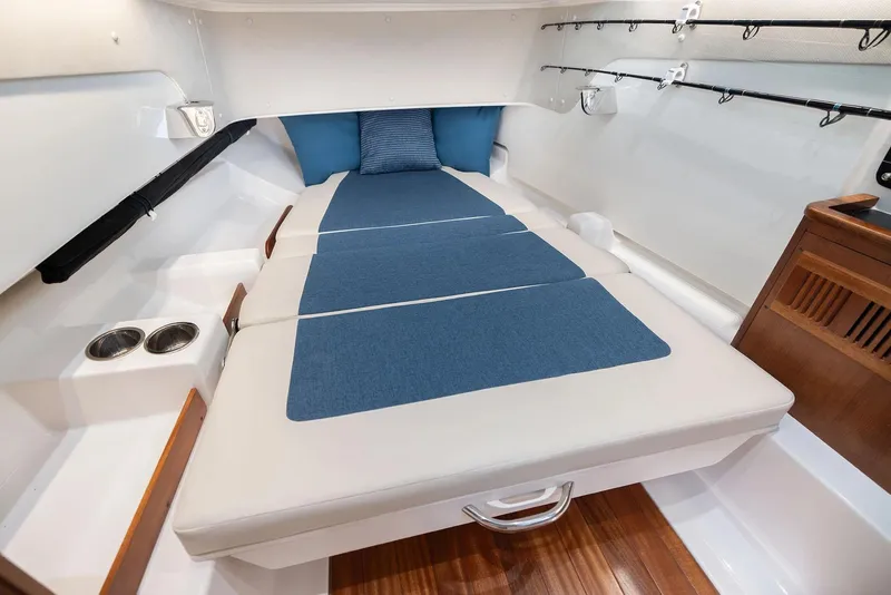 Slide: The Image of Manufacturer Provided Image: 2025 Pursuit S 328 Sport cabin interior with blue cushions and wooden accents. - 17
