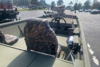Slide: The Image of 2019 Lowe Roughneck 1860CC boat with camo seats in a parking lot. - 2