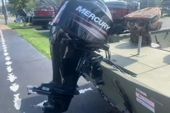Slide: The Image of 2019 Lowe Roughneck 1860CC boat with Mercury outboard motor, parked on pavement. - 4