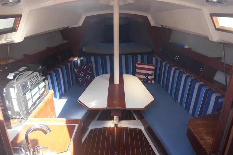 Slide: The Image of Interior of 1986 Hunter 28.5 sailboat with striped seating and wooden table. - 10