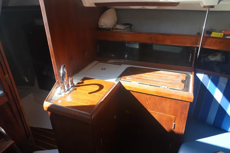 Slide: The Image of Interior of 1986 Hunter 28.5 sailboat galley with wooden cabinetry and sink. - 16