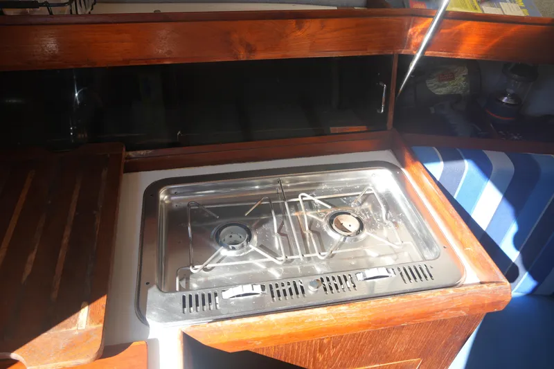 Slide: The Image of 1986 Hunter 28.5 yacht interior with a compact two-burner stove in a wooden galley. - 18