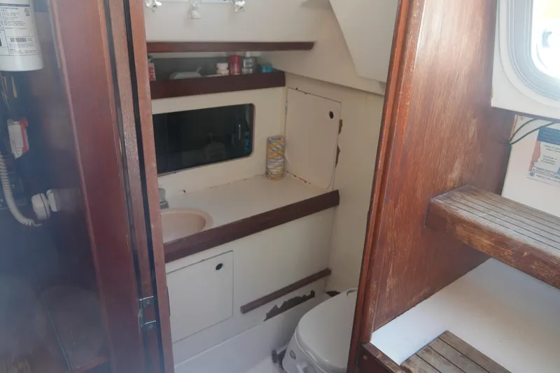 Slide: The Image of Interior of 1986 Hunter 28.5 sailboat bathroom with wooden accents and compact design. - 19
