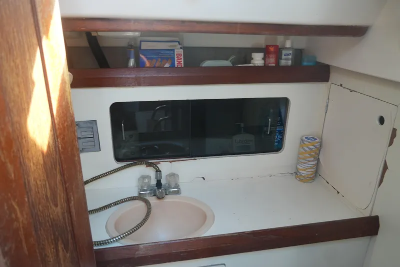 Slide: The Image of 1986 Hunter 28.5 sailboat bathroom with sink, mirror, and storage shelves. - 20