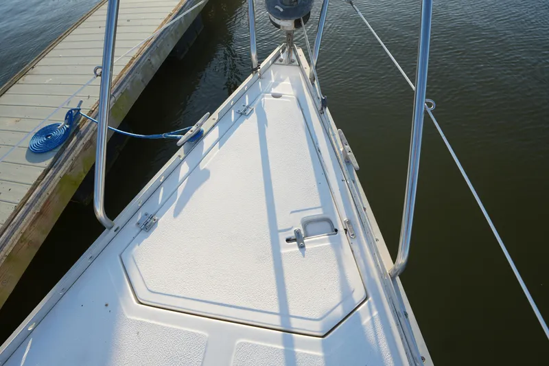 Slide: The Image of Bow of 1986 Hunter 28.5 sailboat docked, showing deck and railing details. - 5