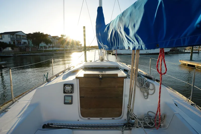 Slide: The Image of 1986 Hunter 28.5 sailboat docked at sunset, featuring blue sail cover. - 9