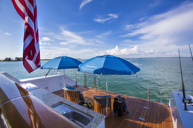 Slide: The Image of Luxurious 2002 Christensen Tri Deck yacht deck with blue umbrellas and ocean view. - 17