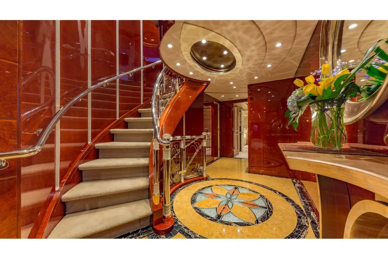 Slide: The Image of Luxurious interior of 2002 Christensen Tri Deck yacht with elegant staircase and floral arrangement. - 33