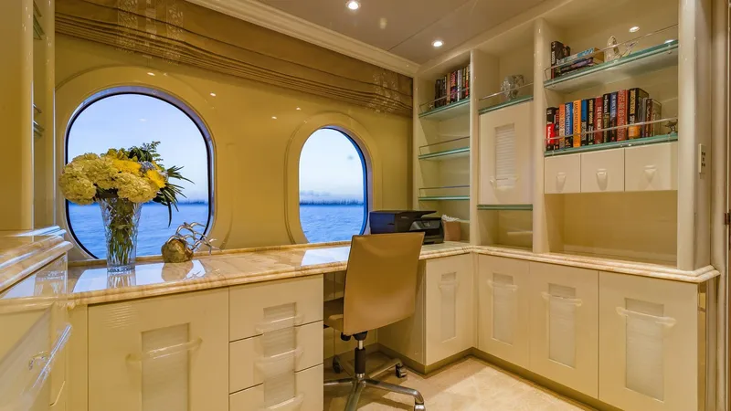 Slide: The Image of Luxurious yacht office with ocean view, elegant desk, bookshelves, and floral arrangement. Christensen Tri Deck 2002. - 36