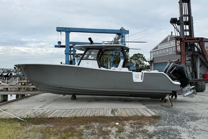 The Image of 2026 Sportsman Open 322 Center Console boat on dry dock at marina. - 0