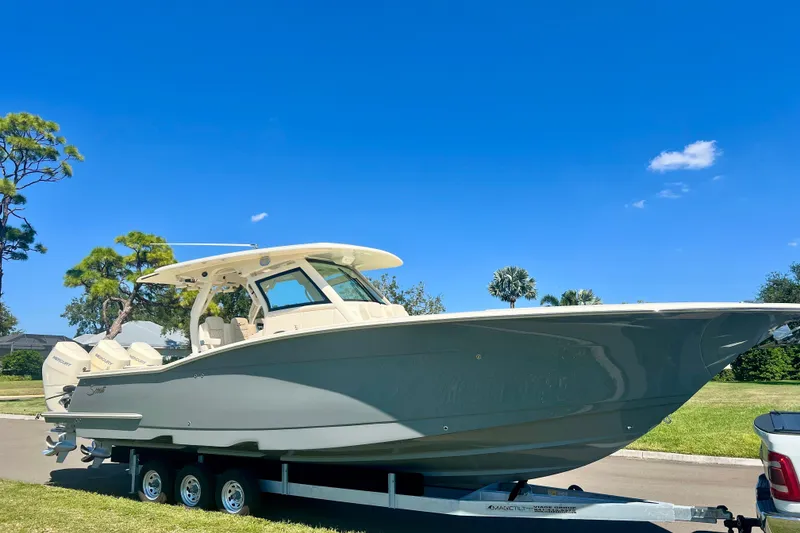 The Image of 2026 Scout 357 LXF boat on water with modern buildings in background. - 0