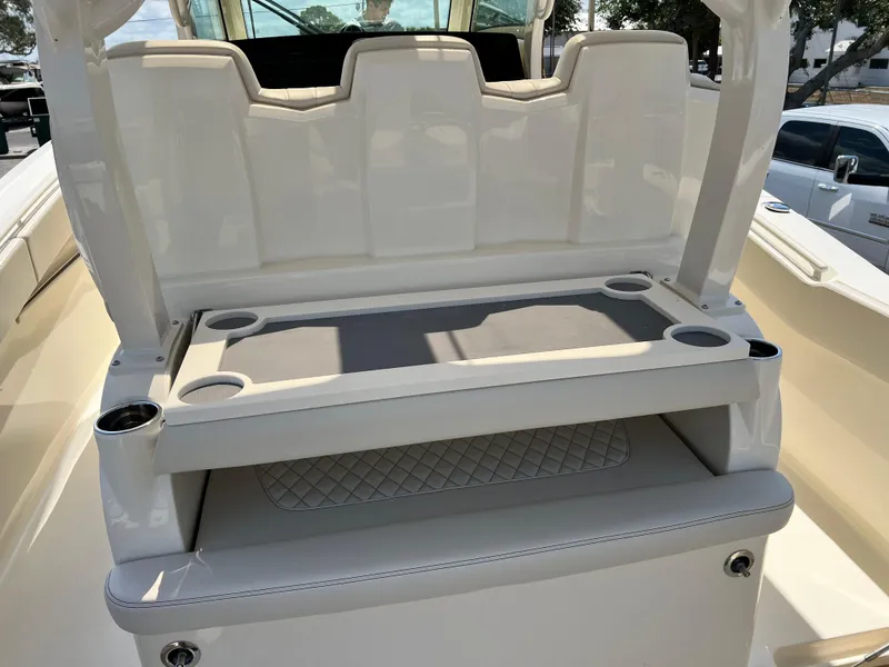 Slide: The Image of 2026 Scout 357 LXF boat with luxurious seating, docked by a scenic waterfront. - 17