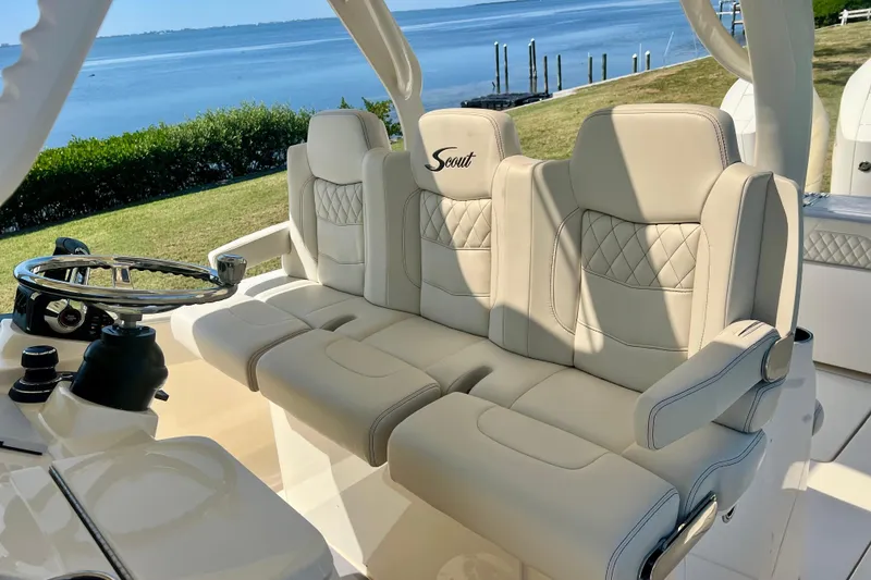 Slide: The Image of 2026 Scout 357 LXF boat with luxurious seating, overlooking a scenic waterfront. - 21