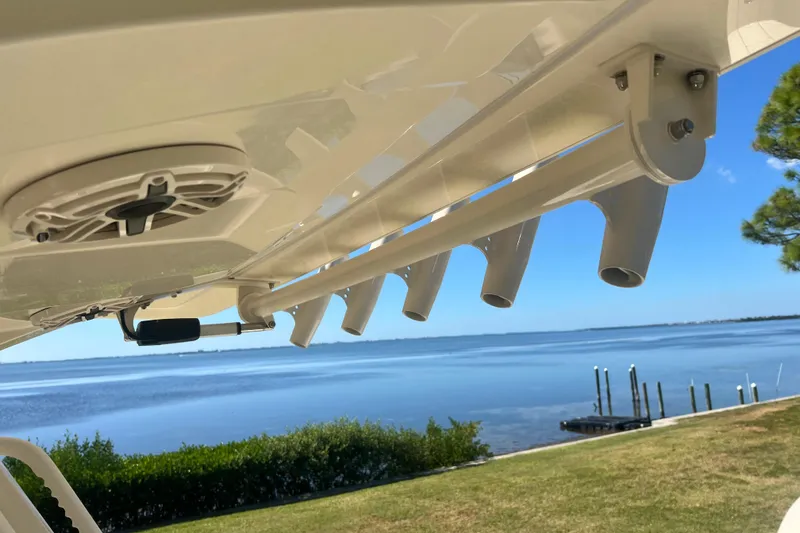 Slide: The Image of 2026 Scout 357 LXF boat detail with rod holders and speaker, overlooking serene waterfront. - 41