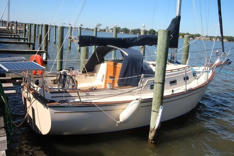 Slide: The Image of 1990 Island Packet 27 sailboat docked with solar panel and covered cockpit. - 1
