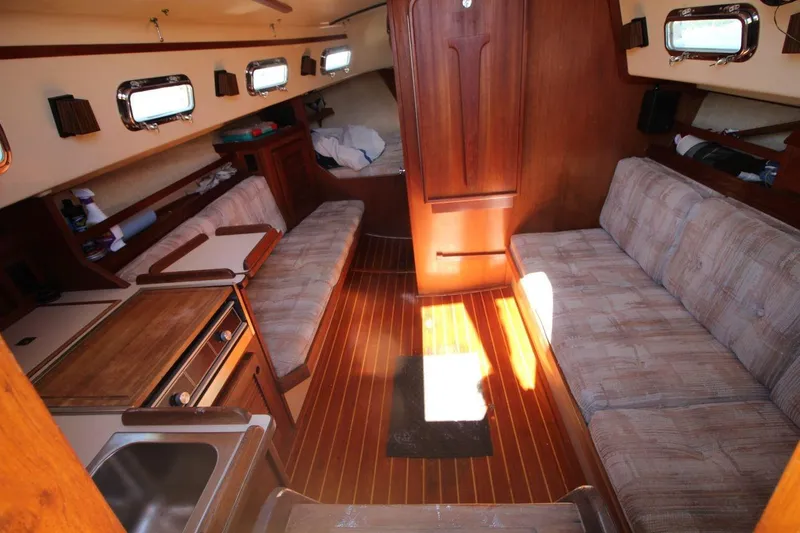 Slide: The Image of Interior of 1990 Island Packet 27 sailboat with cozy seating and wooden finishes. - 11