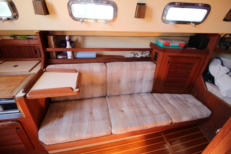 Slide: The Image of 1990 Island Packet 27 interior with cushioned seating and wooden cabinetry. - 13