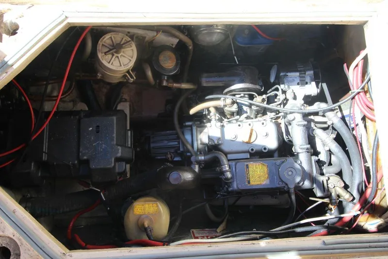 Slide: The Image of Engine compartment of a 1990 Island Packet 27 sailboat, showing mechanical components and wiring. - 19