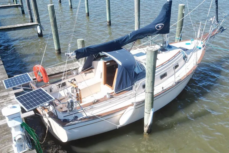 Slide: The Image of 1990 Island Packet 27 sailboat docked with solar panels and lifebuoy. - 2