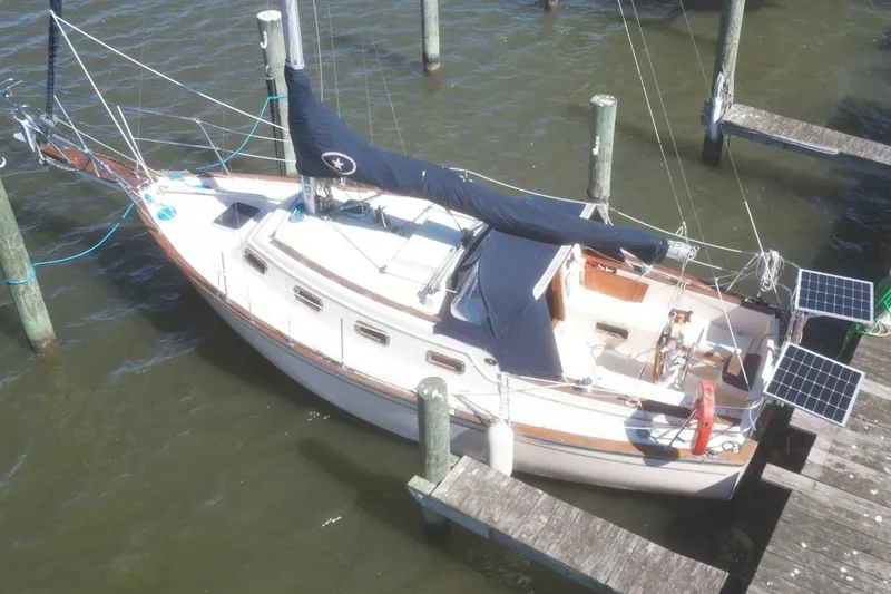 Slide: The Image of 1990 Island Packet 27 sailboat docked, featuring solar panels and classic design. - 5