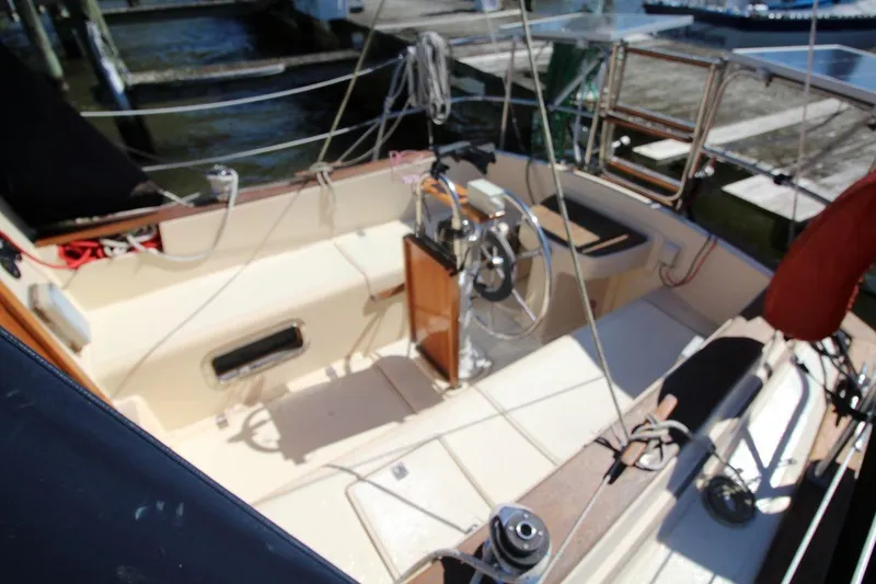 Slide: The Image of 1990 Island Packet 27 sailboat cockpit with steering wheel and rigging. - 7