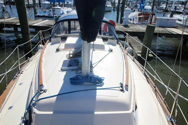 Slide: The Image of 1990 Island Packet 27 sailboat docked at marina, showcasing deck and rigging. - 9