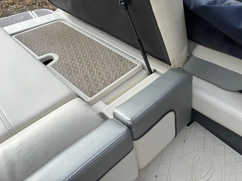 Slide: The Image of 2010 Sea Ray 210 SL SS boat interior with cushioned seating and textured flooring. - 10