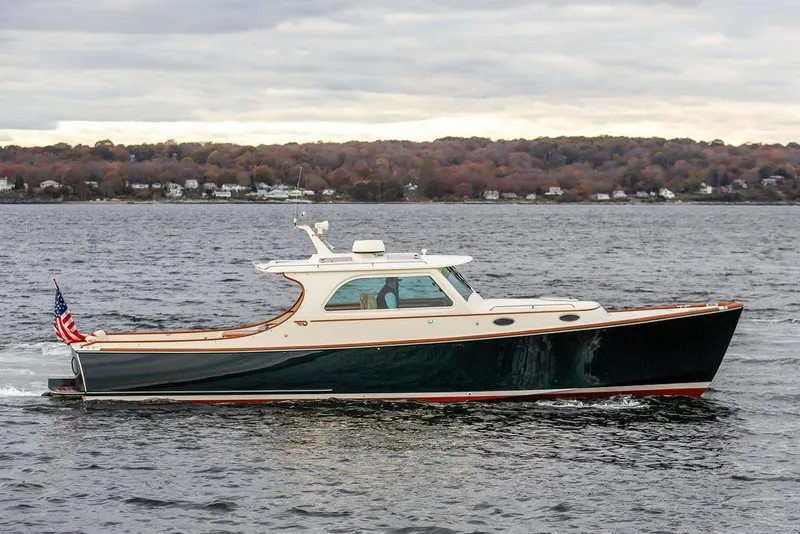 The Image of 2004 Hinckley Picnic Boat EP cruising on a scenic lake, certified pre-owned. - 0