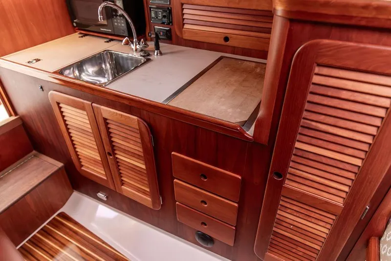 Slide: The Image of 2004 Hinckley Picnic Boat EP interior with wooden cabinetry and stainless steel sink. - 18