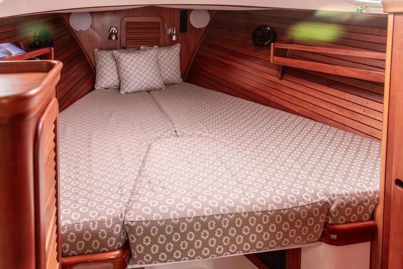 Slide: The Image of 2004 Hinckley Picnic Boat EP cabin with cozy bed and wooden interior. - 20
