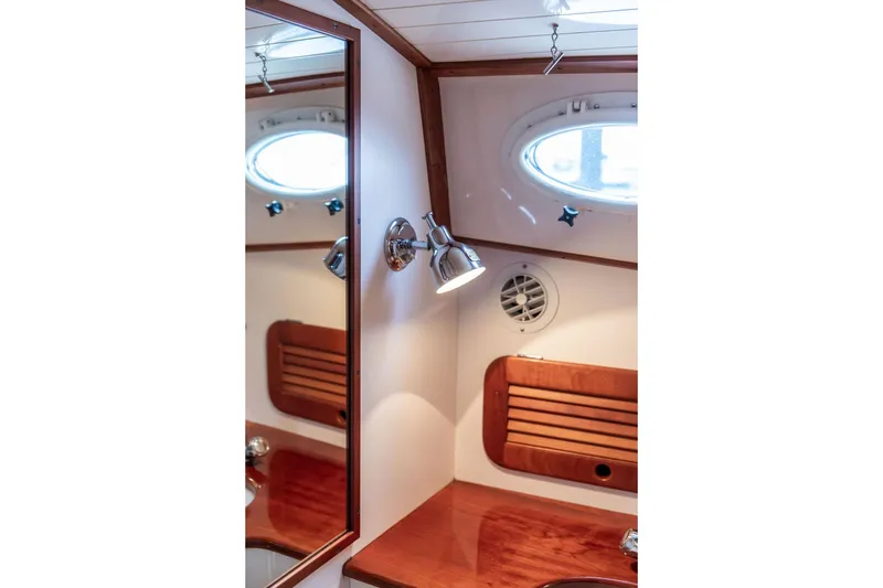 Slide: The Image of 2004 Hinckley Picnic Boat EP interior with wooden accents and porthole window. - 24