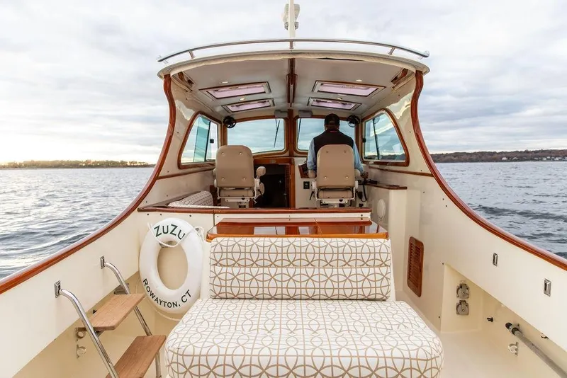 Slide: The Image of 2004 Hinckley Picnic Boat EP on water, interior view with seating and helm. - 7