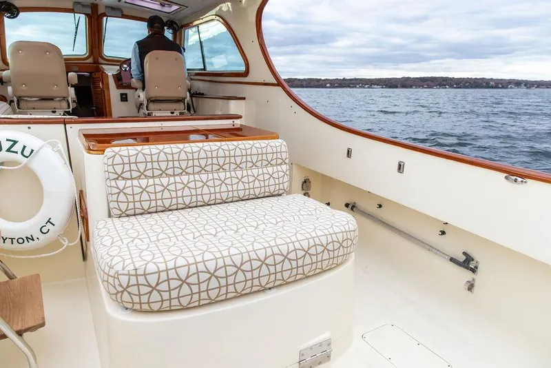 Slide: The Image of 2004 Hinckley Picnic Boat EP interior with patterned seating, cruising on open water. - 8