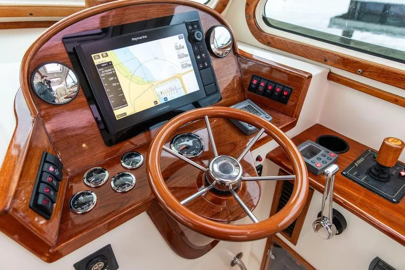 Slide: The Image of 2004 Hinckley Picnic Boat EP helm with wooden steering wheel and navigation display. - 11